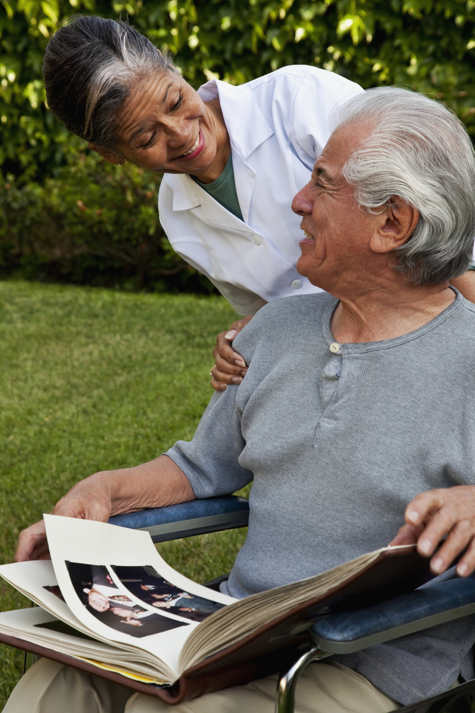 Female caregiver overlooking man on wheelchair